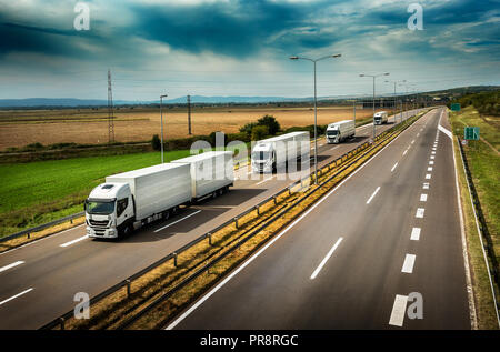 Wohnwagen oder Konvoi von Weißen Lkw Lkw in Linie auf ein Land Autobahn Stockfoto