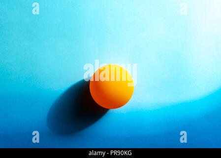 Minimalistische Sonnenuntergang am Meer abstrakt. Ping Pong Ball auf blauem Hintergrund Papier. Stockfoto