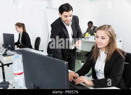 Gut aussehender bärtiger Mann reden und flirten mit attraktiven lächelnde Frau arbeiten bei co-Arbeitsbereich Stockfoto