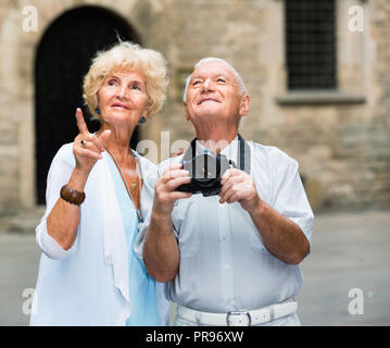 Happy positive lächelnde älteres Ehepaar auf, die zusammen reisen, fotografieren Sehenswürdigkeiten der Stadt mit der Kamera Stockfoto