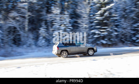 Ein Auto fahren einen Berg in verschneite Straßenverhältnisse. Stockfoto