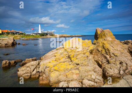 An der felsigen Küste der Ostsee in Allinge, Bornholm, Dänemark. Schornstein der Räucherei im Hintergrund. Stockfoto