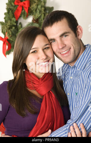 Liebevolle junge Paar Sharing a Christmas moment, USA Stockfoto