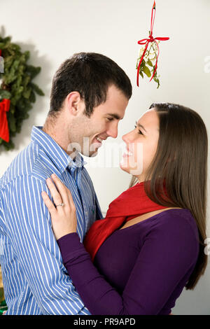 Liebevolle junge Paar Sharing a Christmas moment, USA Stockfoto