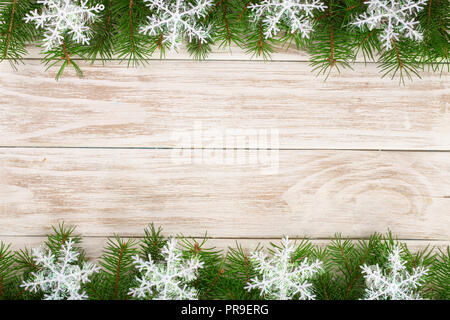 Weihnachten Rahmen aus Tannenzweigen mit Schneeflocken auf einem hellen Hintergrund Stockfoto