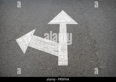Weiße Pfeile auf Asphalt-Straße Pfeil Stockfoto