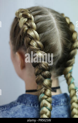 Zwei dicke Zöpfe mit einem Kanekalon auf hellen Haar, eine jugendliche Frisur Stockfoto