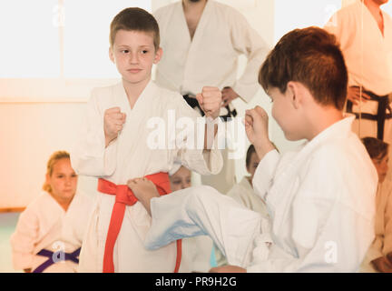 Gewöhnliche boys Ausbildung in paar Karate Technik während der Klasse zu verwenden Stockfoto