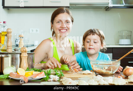 Frau tun Lachs Fisch Knödel Füllung und Salzteig in der Küche Stockfoto