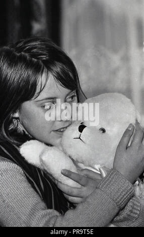1970 s, einem Mädchen, das Fest oder ihr weiches Spielzeug, England, UK kuscheln Holding. Stockfoto