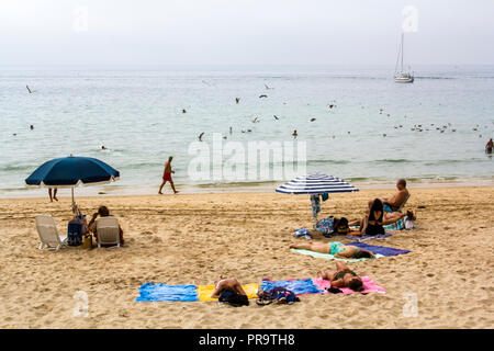 SESIMBRA, PORTUGAL - ca. September 2018: Nicht identifizierte Personen am Strand an einem nebligen Tag Stockfoto