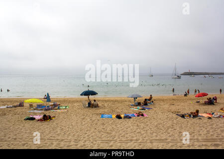 SESIMBRA, PORTUGAL - ca. September 2018: Nicht identifizierte Personen am Strand an einem nebligen Tag Stockfoto