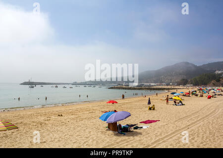 SESIMBRA, PORTUGAL - ca. September, 2018: die Menschen am Strand an einem nebligen Tag Stockfoto