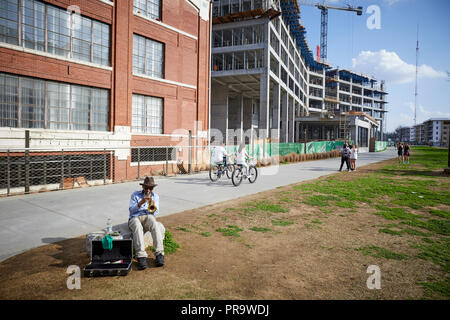 Atlanta, Hauptstadt des US-Bundesstaates Georgia, Menschen, Fahrrädern auf einem Gehweg mit einem Mann in den Vordergrund seiner Trompete zu spielen Stockfoto