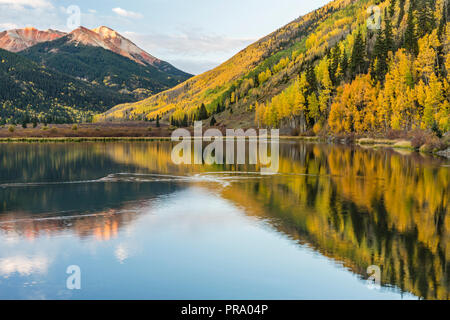 Die roten Berge und goldene Espen auf Hayden Berg spiegelt sich in Crystal Lake in den Uncompahgre National Forest im Süden von Ouray, Colorado. Stockfoto