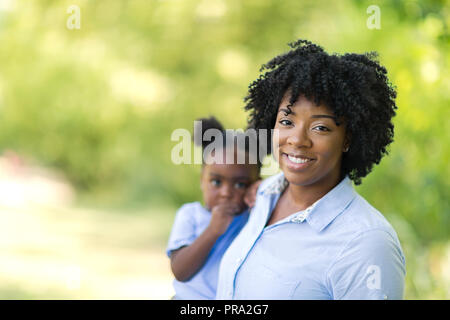 Portrait einer afrikanischen amerikanischen Mutter ihr kleines Mädchen hält. Stockfoto