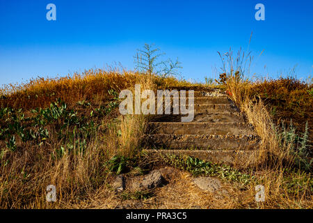 Treppen auf der Wiese. Ungleichmäßige Schritte vom Boden führen auf den Hügel. Stockfoto