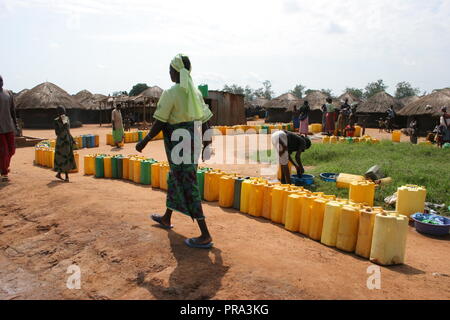 Eine lange Linie der Kanister warten an einem wasserbohrloch in Atiak intern der Menschen (IDP) Camp vertriebenen, Norduganda gefüllt zu werden. Stockfoto