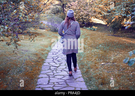 Frau in grauer Deckel und Mantel stehen im Herbst Natur. Stockfoto