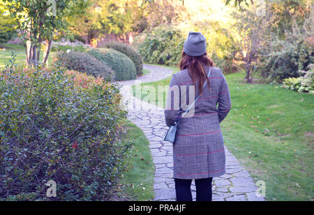 Frau in grauer Deckel und Mantel stehen im Herbst Natur. Stockfoto