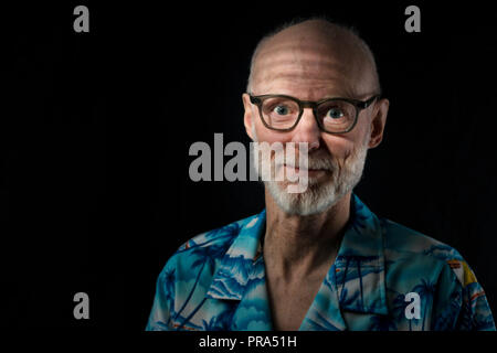 Portrait von junger älterer Mann in Hawaii Hemd auf schwarzem Hintergrund Stockfoto