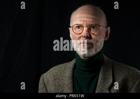 Portrait von älteren Geschäftsmann in Freizeitkleidung auf schwarzem Hintergrund Stockfoto