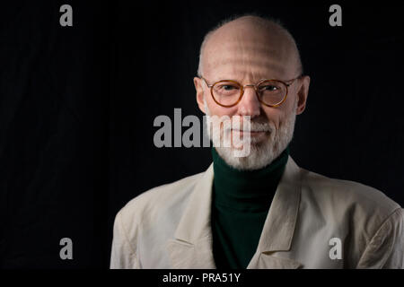 Portrait von lächelnden älteren Geschäftsmann auf schwarzem Hintergrund Stockfoto