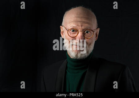 Portrait von Happy älterer Mann auf schwarzem Hintergrund Stockfoto