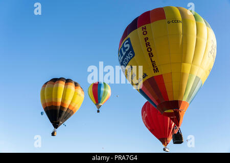 Vier Heißluftballons steigen beim York Balloon Fiesta, North Yorkshire, England, Großbritannien, an. Stockfoto