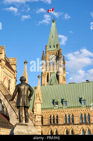 OTTAWA, Kanada - 5. Mai 2018: Parliament Hill Center Gebäude, Bibliothek und eine Statue. Parliament Hill ist ein Bereich der Krone Land auf der südlichen Ba Stockfoto