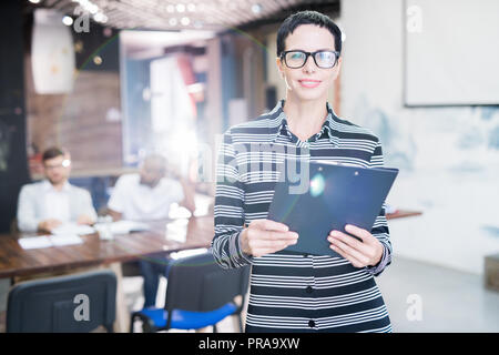 Lächelnd weibliche Manager mit Zwischenablage Stockfoto