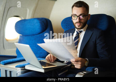 Stattliche Business Mann arbeitet in der Ebene Stockfoto