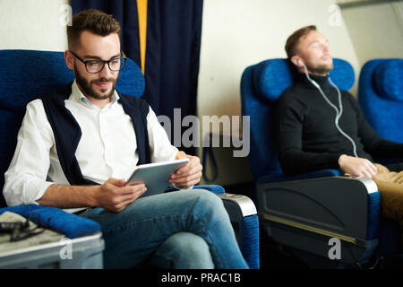 Mann mit Tablet in der Ebene Stockfoto