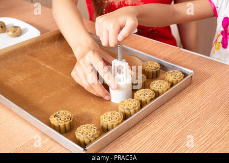 In der Nähe von menschlichen Händen, Mond Kuchen in der Küche zu Hause. Stockfoto