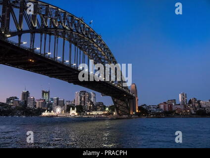 Blick auf Sydney Harbour Bridge nach Sonnenuntergang an der blauen Stunde mit Luna Park im Hintergrund genommen Stockfoto