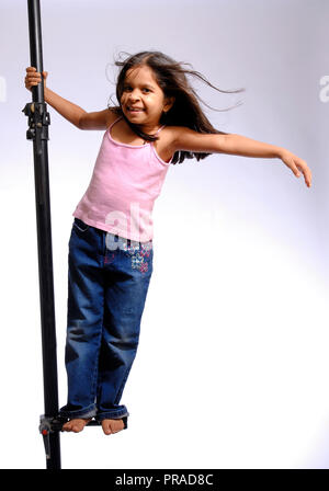 Porträt eines jungen Mädchens auf einer Stange mit FYLING HAAR IN VERSCHIEDENEN EMOTIONEN. Aufnahme im Studio auf einen einfachen Hintergrund Stockfoto
