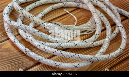 Gestreiften weißen Seil liegt auf dem braunen Tisch Stockfoto