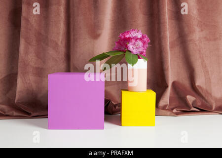 Bicolor Vase mit Blumen rosa Rhododendron innen und Würfel gefärbt. Minimale noch leben Farbe Fotografie Stockfoto