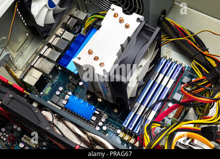 Computer motherboard Draufsicht sichtbar Kühlkörper, Lüfter, RAM-Speicher, Grafikkarte, Netzteil und Kabel. Stockfoto