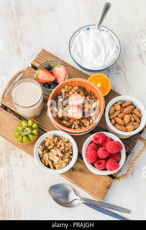 Oat kostenlose paleo Mutter und Früchte Müsli mit Früchten und Beeren, Mutter Milch, Kokosnuss Joghurt serviert, Vertikal, selektiven Fokus Stockfoto