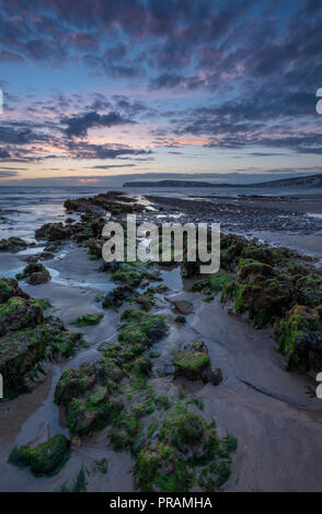 Compton Bay, Isle of Wight, Großbritannien. 30. September 2018. Einen schönen und stimmungsvollen Sonnenuntergang über dem Strand und Felsen an Compton Bucht auf der Insel Wight. Kühler herbst Wetter bringt einen bewölkten Himmel und Moody auf das Meer und die Klippen bei Ebbe. Sonnenuntergang Farben im nassen Sand reflektiert und Algen Felsen bedeckt. Quelle: Steve Hawkins Fotografie/Alamy leben Nachrichten Stockfoto