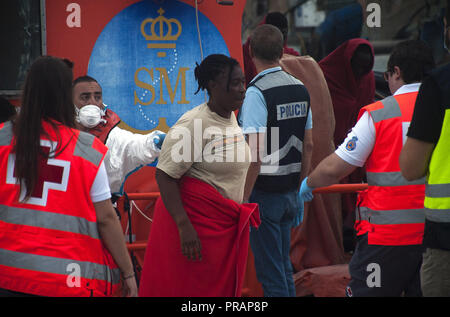 Malaga, Malaga, Spanien. 30 Sep, 2018. Ein Migrantinnen gesehen durch Rettungskräfte Aussteigen aus einem Rettungsboot geholfen, nach Ihrer Ankunft im Hafen von Málaga in Spanien Maritime Rescue Service gerettet 96 Subsaharischen und marokkanischen Migranten an Bord zwei jollen am Mittelmeer und brachte sie nach Malaga Hafen, wo sie durch das Spanische Rote Kreuz unterstützt wurden. Credit: Jesus Merida/SOPA Images/ZUMA Draht/Alamy leben Nachrichten Stockfoto