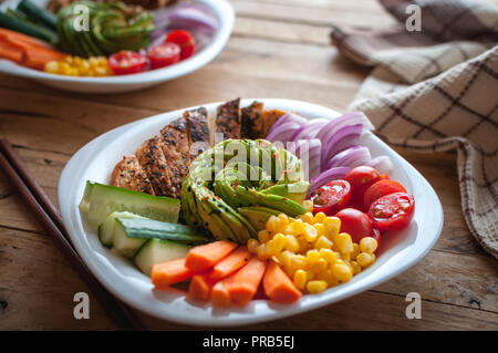 Close-up Buddha Schüssel mit Hähnchen und Gemüse auf hölzernen Hintergrund Stockfoto