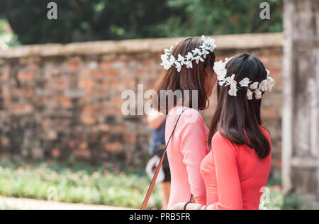 Studentinnen in formelle Kleidung und Blume Kronen gekleidet ihre Universität Abschluss feiern. Tempel der Literatur, Hanoi. Stockfoto