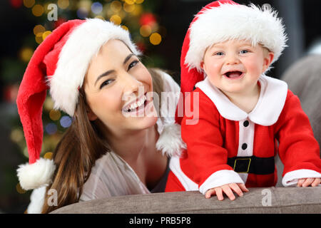 Glückliche Mutter und Sohn an der Kamera in Weihnachten auf einer Couch im Wohnzimmer zu Hause liegen auf der Suche Stockfoto