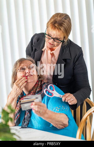 Finanzielle Berater Übergabe Schere zu den älteren Dame Holding Kreditkarten. Stockfoto