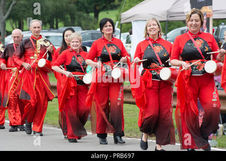 Eine chinesische Taille Drum Team, bunt gekleidet in der Tracht, führt zu einem Volksfest. Stockfoto