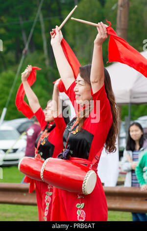 Eine chinesische Taille Drum Team, bunt gekleidet in der Tracht, führt zu einem Volksfest. Stockfoto