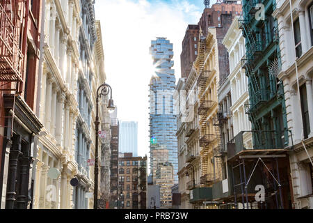 Sonnenlicht strahlt am Gebäude entlang Greene Street mit Blick auf die Kreuzung an der Canal Street in Soho in Manhattan, New York City Stockfoto