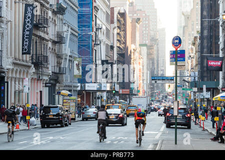 NEW YORK CITY, ca. 2018: Street View den Broadway hinunter schauen, ist besetzt mit Menschen, Autos und Fahrräder an einem sonnigen Tag im Viertel SoHo von Manhattan, Stockfoto